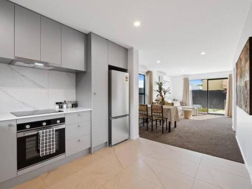 a kitchen with white appliances and a dining room at Spa Hideaway in Central City with Parking in Christchurch