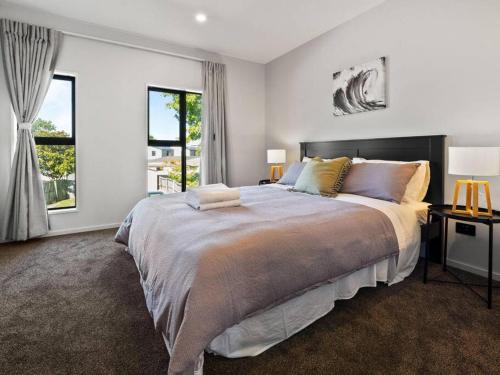 a bedroom with a large bed and a large window at Spa Hideaway in Central City with Parking in Christchurch