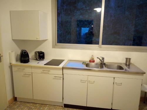 une cuisine avec un évier et une fenêtre dans l'établissement Central et calme, vue ville et mer, parking privé, ascenseur, au Havre