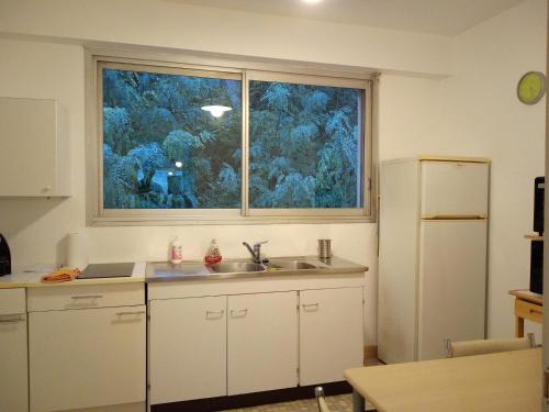 une cuisine avec un évier et une grande fenêtre dans l'établissement Central et calme, vue ville et mer, parking privé, ascenseur, au Havre