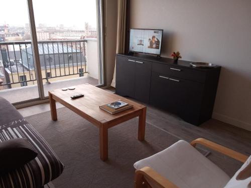 - un salon avec une table basse et une grande fenêtre dans l'établissement Central et calme, vue ville et mer, parking privé, ascenseur, au Havre