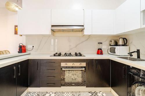 a kitchen with white cabinets and a stove top oven at Villa michlo in El Makina