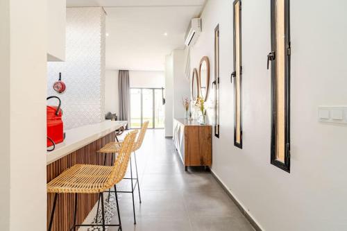 a kitchen with white walls and a counter with chairs at Villa michlo in El Makina