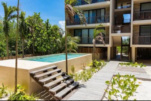 - un bâtiment avec une piscine à côté d'un complexe dans l'établissement Chic Loft Steps from the Beach, à Holbox