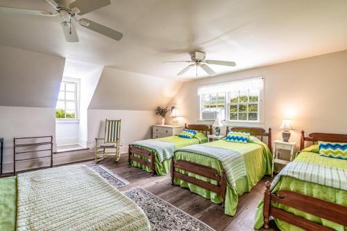 a bedroom with two beds and a ceiling fan at Historic Bliss on Pawleys Island's Shoreline in Pawleys Island