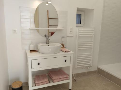 une salle de bain blanche avec un lavabo et un miroir dans l'établissement Chambres d'hôtes, parc, dîner dispo - FR-1-591-701, à Le Blanc