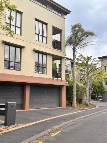 a building with a palm tree in front of it at newmarket fully furnished 2 bedrooms in Auckland