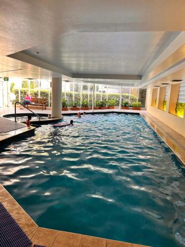 a pool in a hotel with people swimming in it at newmarket fully furnished 2 bedrooms in Auckland