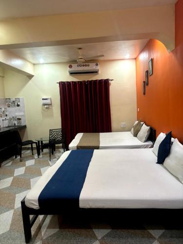 a hotel room with two beds and a red curtain at Hotel Harmony By Heaven in Calangute