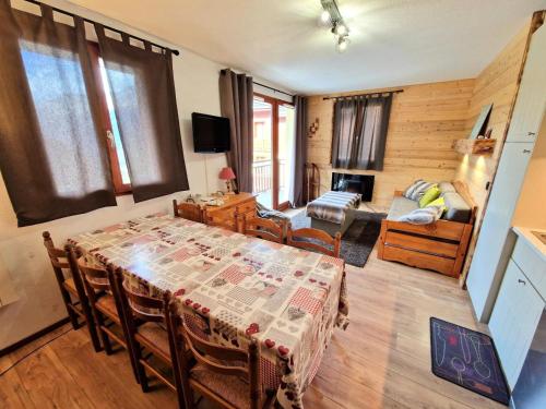 une salle à manger avec une table et un salon dans l'établissement Les Chalets D'arrondaz - Appartement 6/8 personnes 48 m² MAE-2903, à Modane