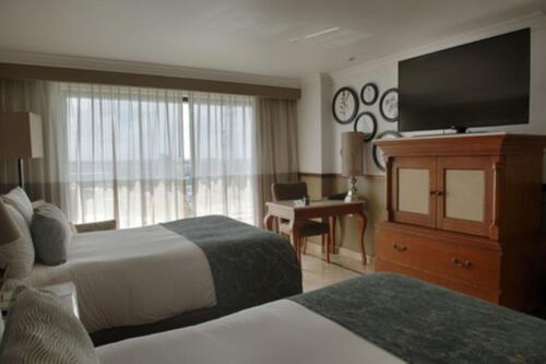 a hotel room with two beds and a flat screen tv at Villahermosa Marriott Hotel in Villahermosa