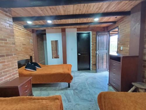 a bedroom with two beds in a brick wall at Posada Rural - La Isabela in Tópaga