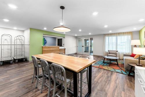 a dining room and living room with a table and chairs at WoodSpring Suites Kansas City Airport in Kansas City