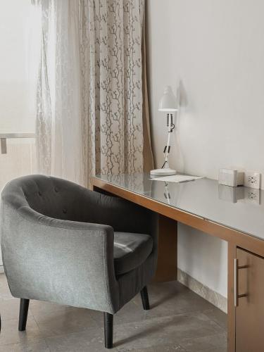 a desk with a chair next to a desk with a lamp at Hotel Catedral La Paz in La Paz