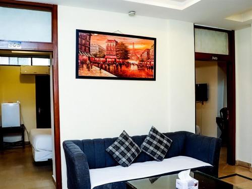 a living room with a blue couch and a painting on the wall at Executive Residency in Islamabad