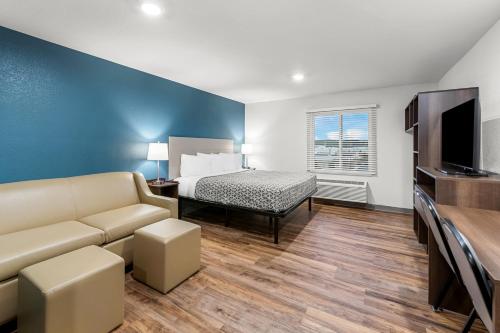 a living room with a couch and a bed at WoodSpring Suites Kansas City Airport in Kansas City