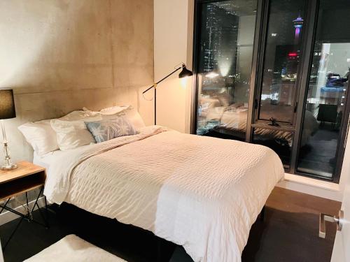 a bedroom with a bed and a desk and a window at LUXURY DT, 2 Bedroom DEAL, Private Balcony, Full Kitchen, Gym - FREE PARKING in Calgary