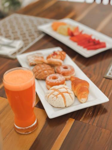 a table with two plates of donuts and a glass of orange juice at Hotel Catedral La Paz in La Paz
