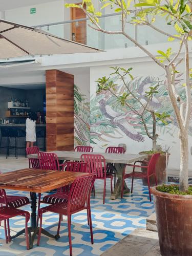 a restaurant with red chairs and tables and a mural at Hotel Catedral La Paz in La Paz