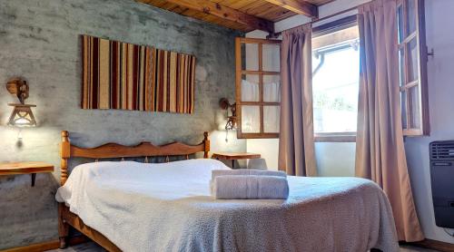 a bedroom with a bed and a window at Cabañas Willy in El Bolsón