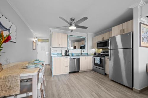 a kitchen with a stainless steel refrigerator and a table at Napili Shores I174 in Kahana