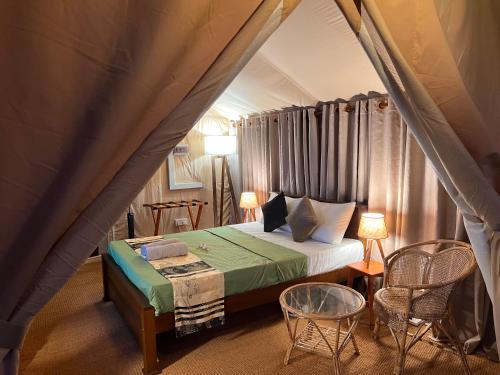a bedroom with a bed in a tent at AT ONE - with Nature Glamping Resort in Rekawa