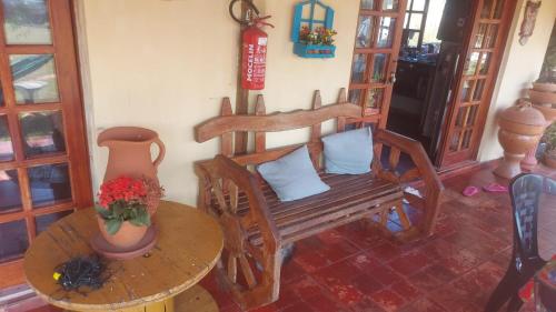 a room with a chair and a table with a vase at Pousada e Camping Tio Wil in Extrema
