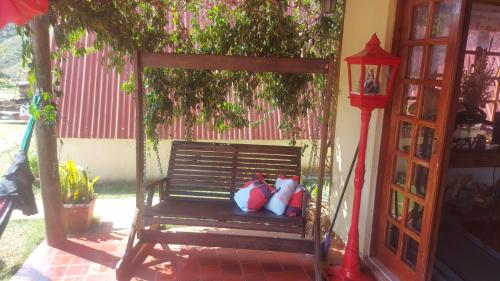 two stuffed animals sitting on a bench next to a tree at Pousada e Camping Tio Wil in Extrema