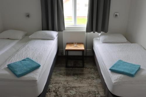 two beds in a room with a table between them at Höfn Hostel in Höfn