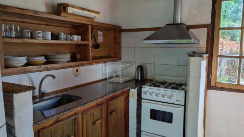 a kitchen with a sink and a stove top oven at Cabañas Willy in El Bolsón