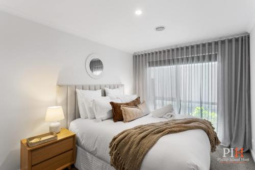 a white bedroom with a large bed and a window at Renovated Lux Property in Quiet Estate in Cowes
