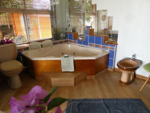 a bathroom with a tub and a toilet and a sink at Maeva Sunset View in Punaauia