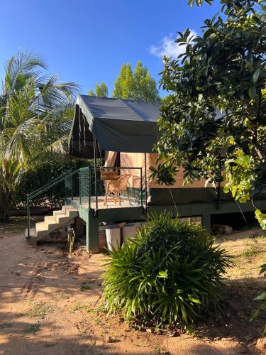 a tent with a table and chairs in front of a house at AT ONE - with Nature Glamping Resort in Rekawa