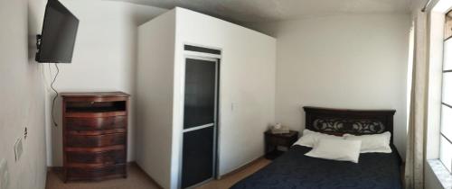 杜伊塔马Hotel Esmeralda Duitama的一间卧室配有一张床,并设有一个通往衣柜的门