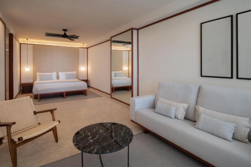 a living room with a couch and a bed at Live Aqua Punta Cana - All Inclusive - Adults Only in Punta Cana
