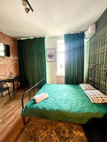 a bedroom with a bed with green sheets and a window at Restauracja Pałacowa Apartamenty in Radzyń Podlaski