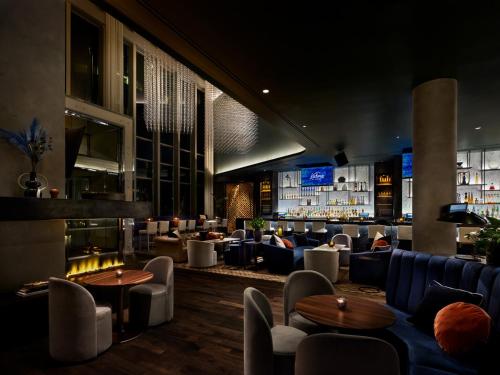 a restaurant with couches and tables and a bar at Paradox Vancouver in Vancouver