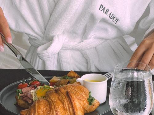 a person sitting at a table with a plate of food at Paradox Vancouver in Vancouver