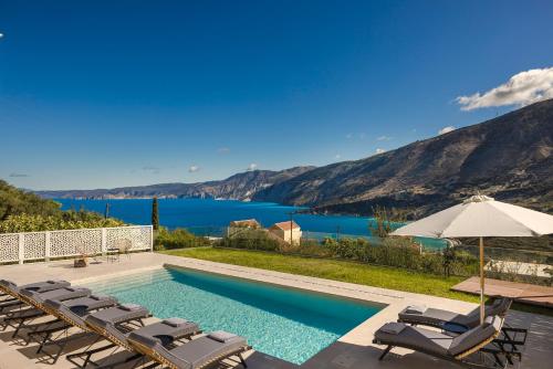 a swimming pool with chairs and a view of the water at aZOLAki Suites in Zóla
