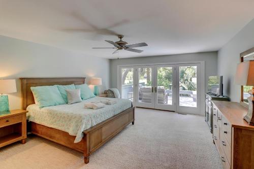 una camera da letto con un letto e un ventilatore a soffitto di Private Pool & Spa - Golf Course Views - Walk to Harbour Town - 24 Stoney Creek Road a Hilton Head Island