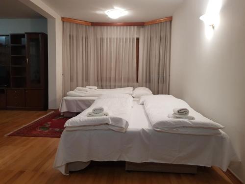 two beds in a room with white sheets and towels at Old Town Villa Sarajevo in Sarajevo