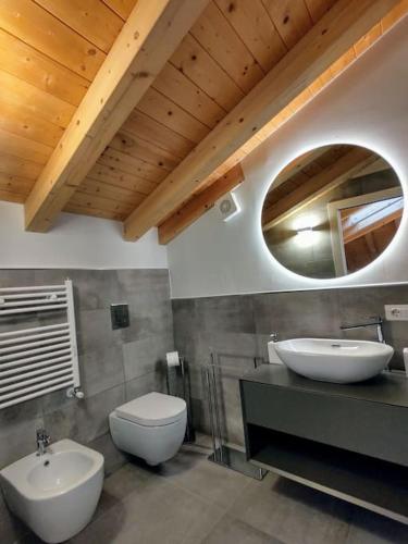 a bathroom with two sinks and a toilet and a mirror at Casa Larius in Como