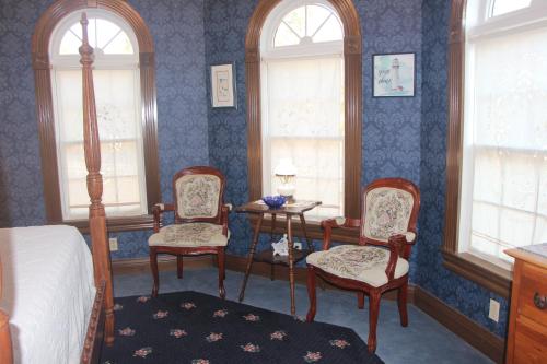 a bedroom with a bed and two chairs and a table at Apple Crest Inn in Gentry