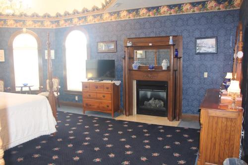 a bedroom with a bed and a tv and a fireplace at Apple Crest Inn in Gentry
