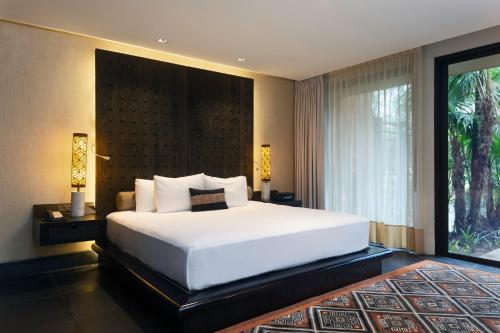 a bedroom with a large bed and a large window at Banyan Tree Mayakoba in Playa del Carmen