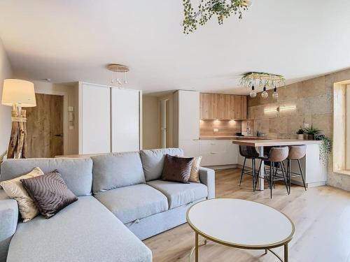 a living room with a couch and a table and a kitchen at Le Barral in Voiron