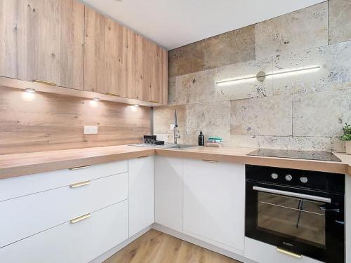 a kitchen with white cabinets and a black oven at Le Barral in Voiron