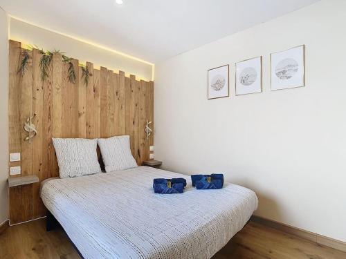 a bedroom with a bed with two blue pillows on it at Le Barral in Voiron