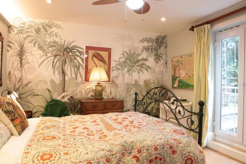 a bedroom with a bed with a tropical wallpaper at Luxor House in London