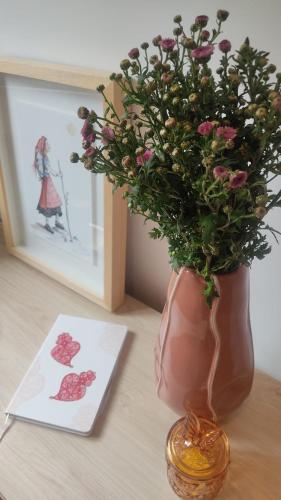 a vase with flowers on a table next to a greeting card at Casa Coral - Lodging & Culture in Braga